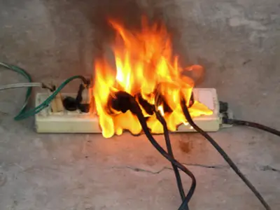 Electrical fire caused by overloaded power strip with burning cords