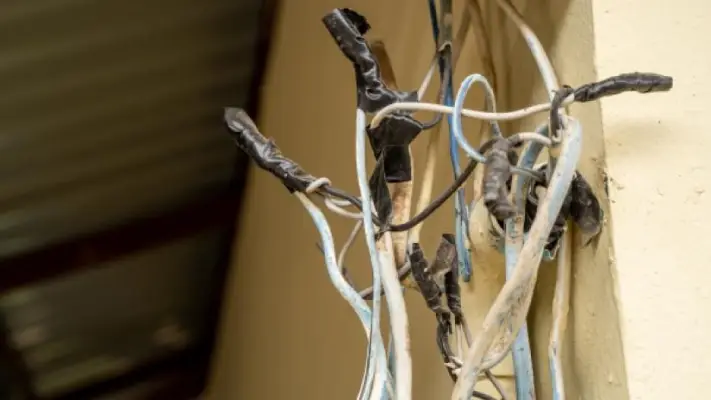 Exposed electrical wiring with deteriorated insulation and improper splices in an older home