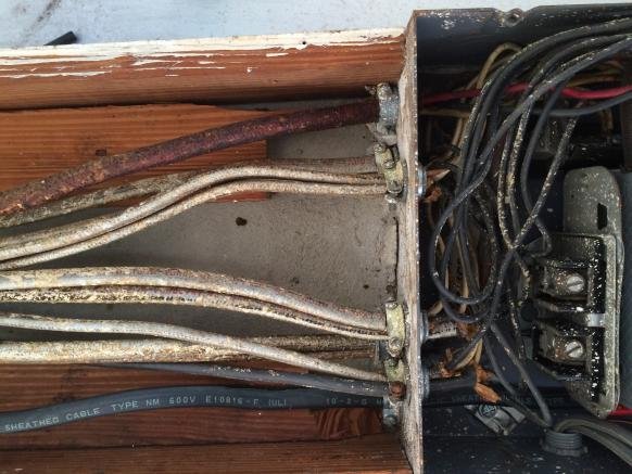 Old cloth-insulated electrical wiring inside a residential electrical panel posing a safety risk