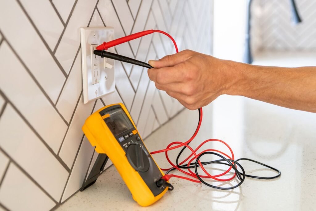 Licensed electrician testing a wall outlet with a multimeter during electrical troubleshooting