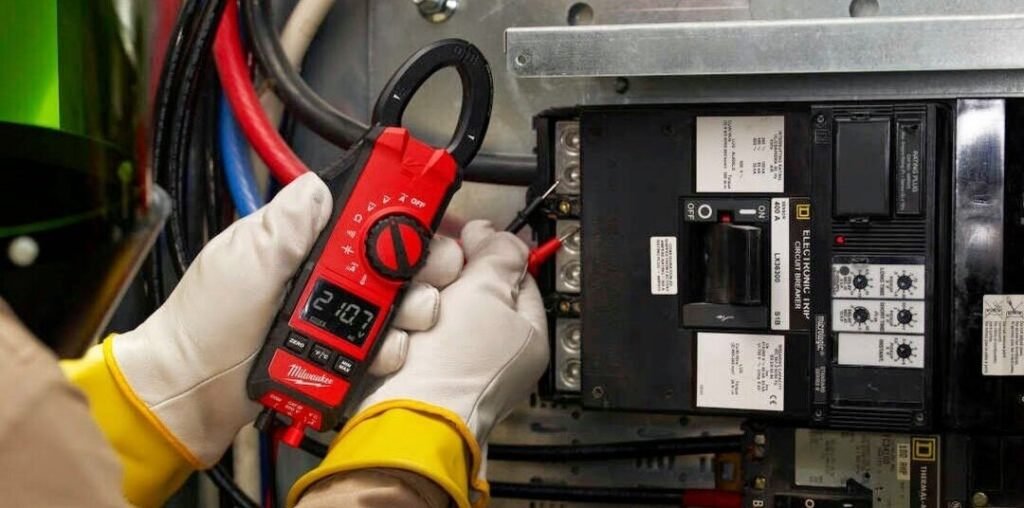 Licensed electrician testing electrical panel with clamp meter during diagnostic service